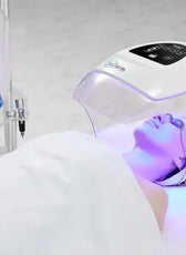 a person laying in a bed with a machine in the background